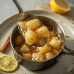 Spoonful of chunky homemade apple sauce from a saucepan