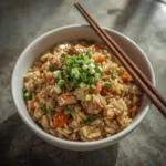 Bowl of turkey fried rice with egg, peas, carrots, green onions and sesame seeds