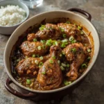 Southern smothered turkey wings in onion gravy in a baking dish with white rice